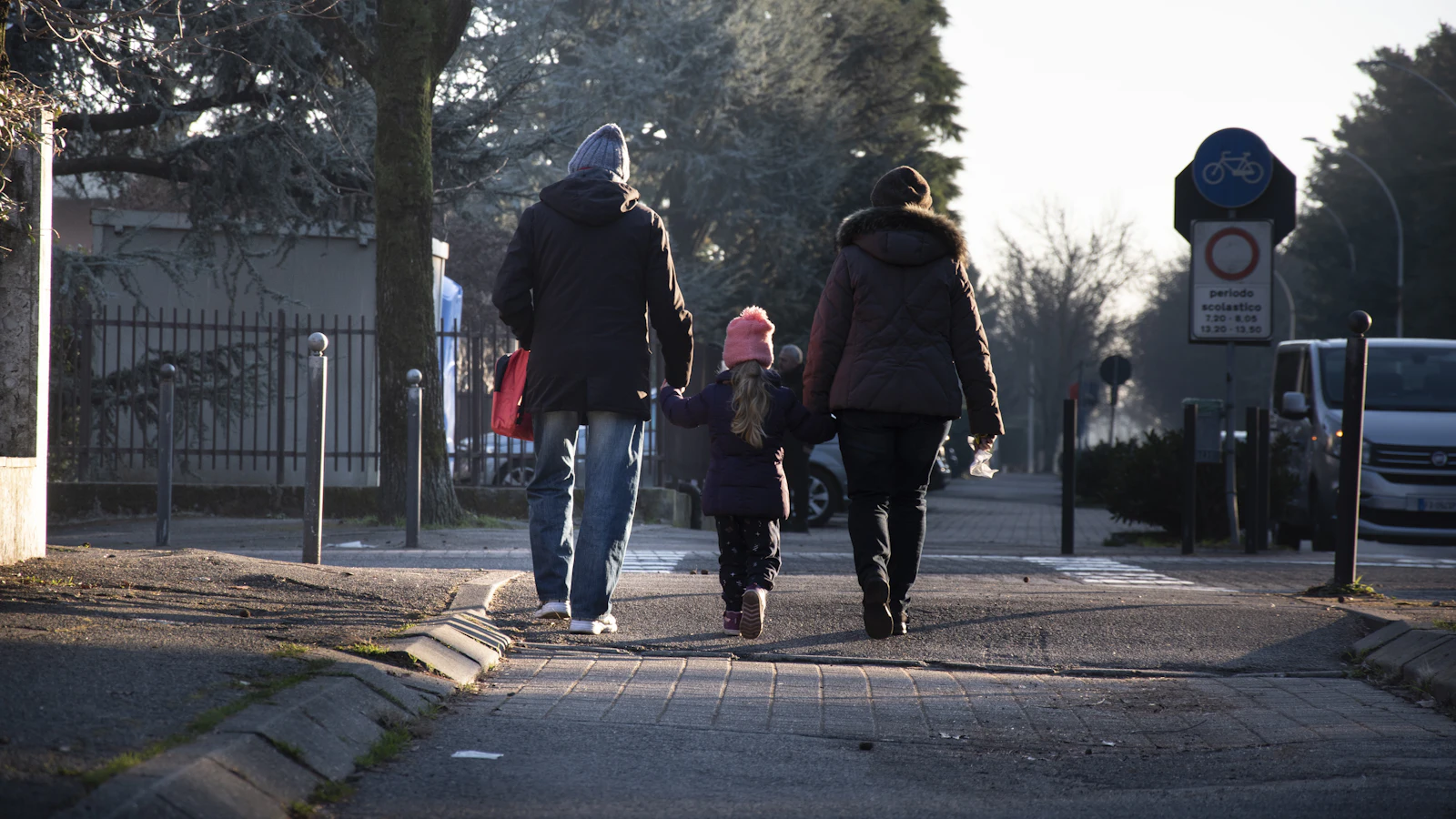 Parents and child walking hand in hand on a winter street