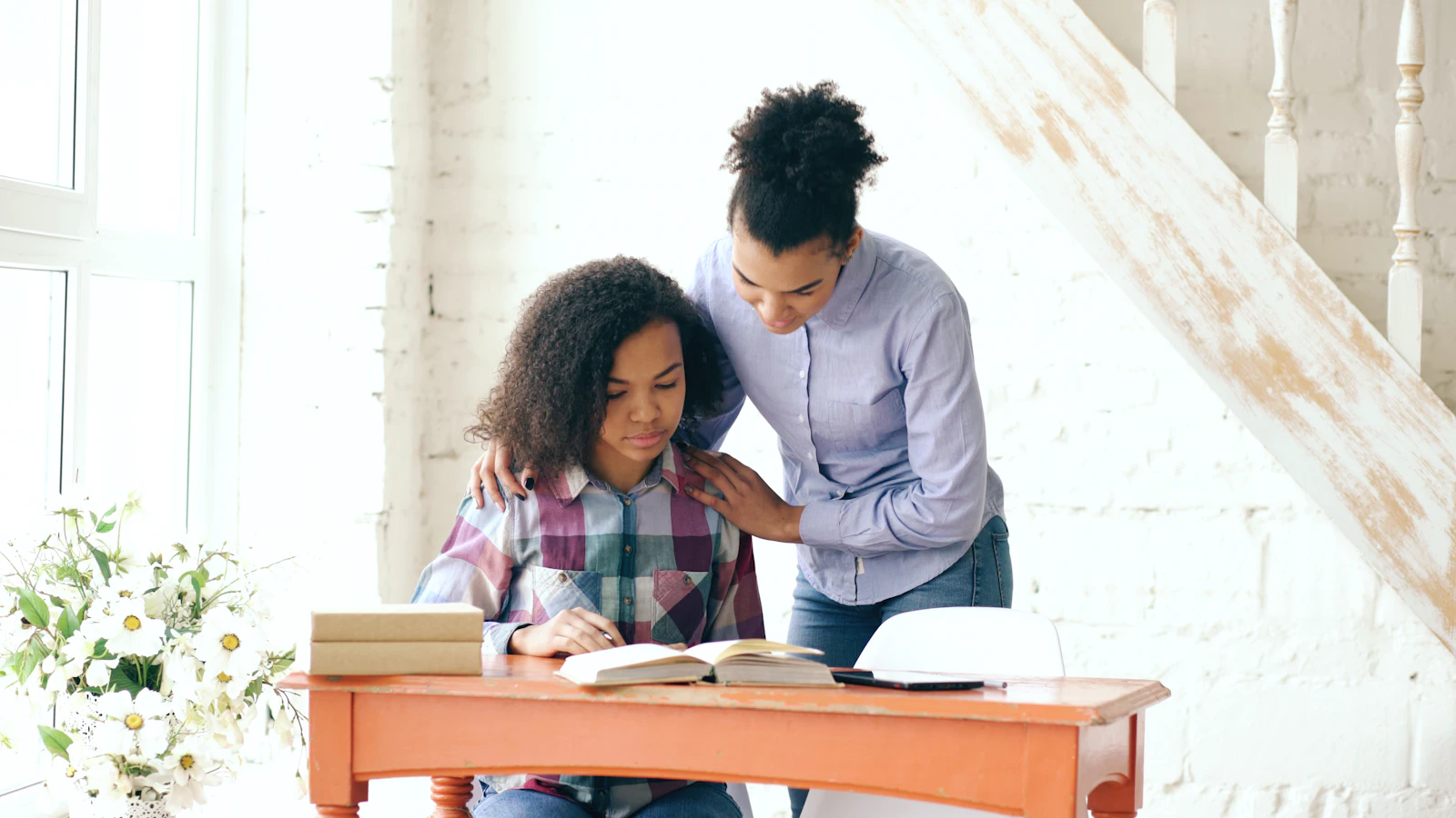 Mother helping her daughter with homework at home